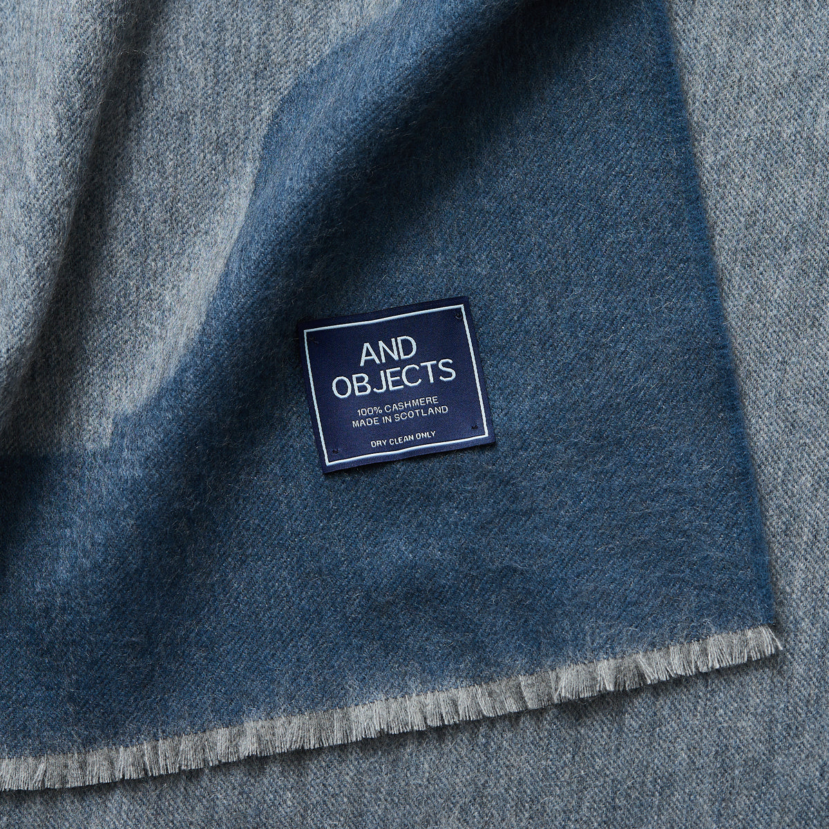 close up of the And Objects label on the Anmore Cashmere Throw Blanket - Slate