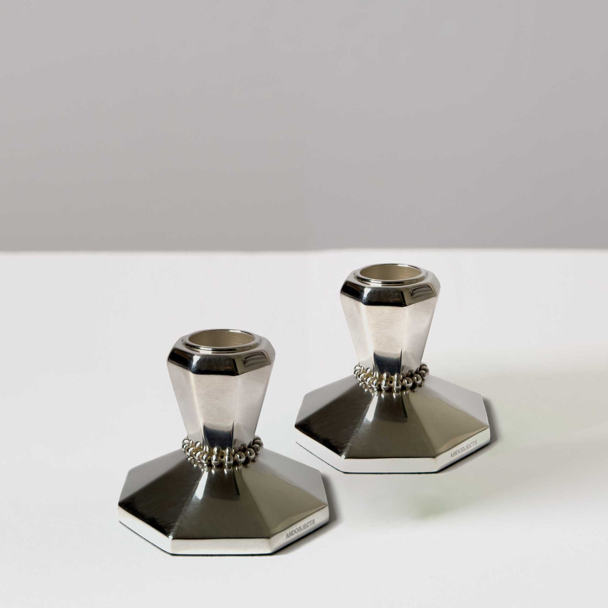 A pair of silver candle holders without tapers