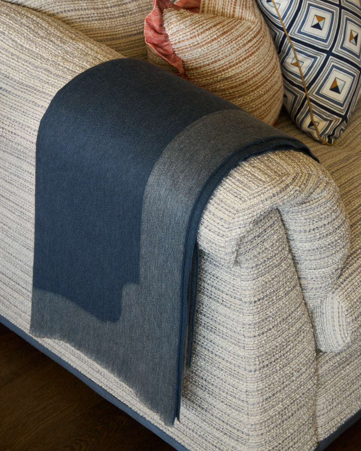Anmore Cashmere Throw Blanket - Slate hung over the arm of a couch