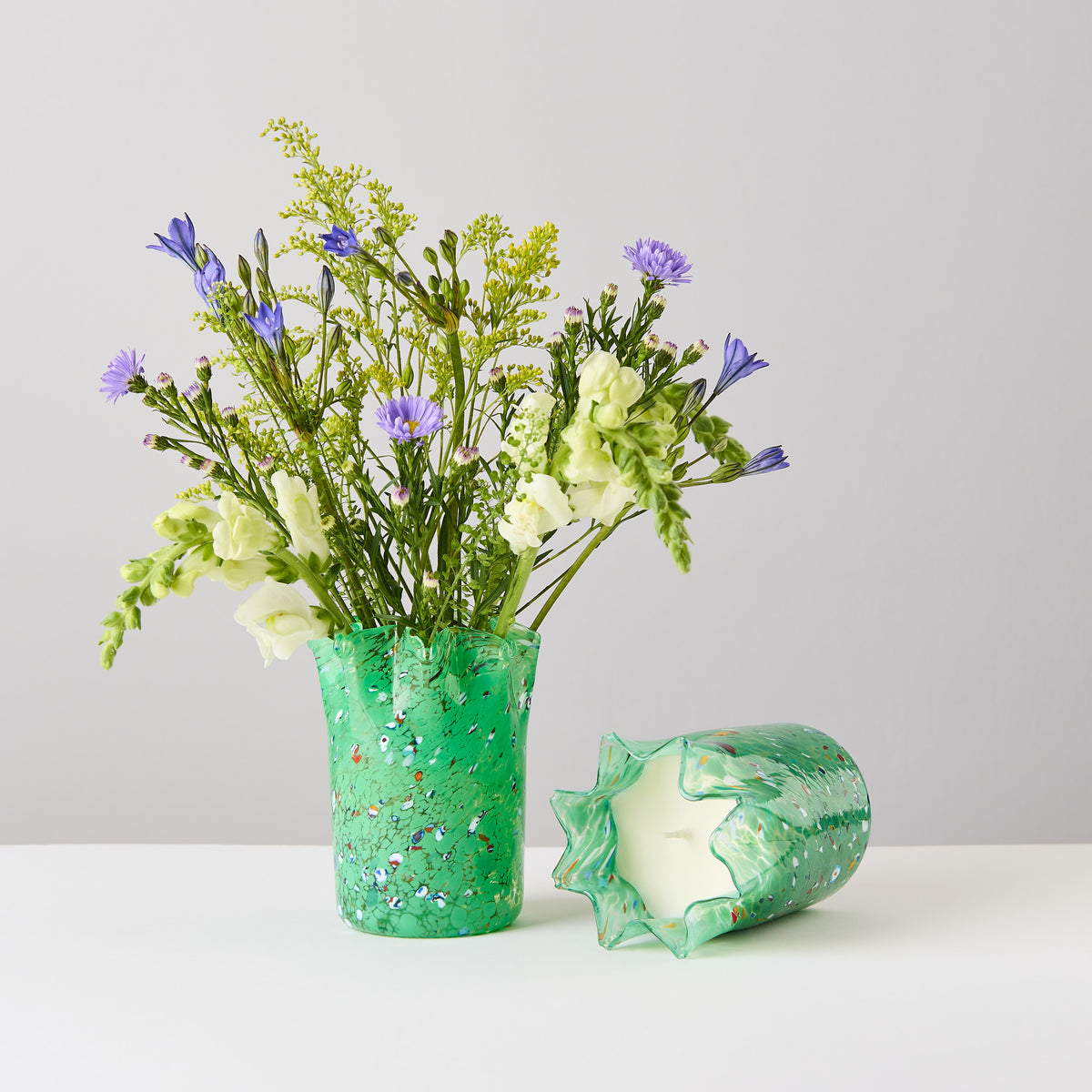 Folium Scented Candle and an empty vessel being used as a vase